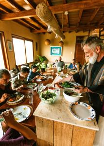 奧爾加諾斯的住宿－AguaMar Vichayito，一群坐在餐桌上吃食物的人