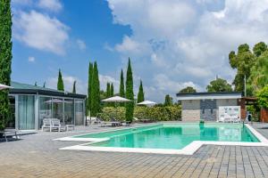 a swimming pool with a patio and a house at Casale Delle Ronde B&B in Latina