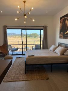 a bedroom with a large bed and a large window at Sol del Valle in Valle de Guadalupe