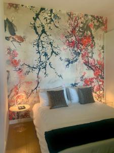1 dormitorio con 1 cama con pared de flores en Tra gli Alberi e il Mare en Sirolo