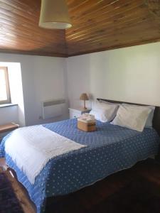 a bedroom with a bed with a blue and white blanket at Casa da Eduardinha in Góis