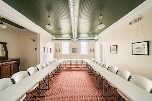 une salle de conférence avec des chaises blanches et une table dans l'établissement The Long Run - 2 CA King Sized Beds+ - Sleeps 8-10, à Lynchburg