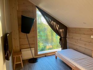 a room with a bed and a large window at Villa Breikki, Himos in Jämsä