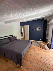 - une chambre avec un lit et un mur bleu dans l'établissement L’Attellu, à Feliceto