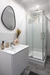 a white bathroom with a sink and a shower at Le Cocon Forestier - Proche aéroport Beauvais, Chantilly, forêt de Hez-Froidmont, parking public gratuit, Wifi & Netflix in Clermont