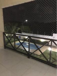 a chain link fence with a basketball court behind it at Refúgio a 20km de Salvador na praia de Jacuípe in Camaçari