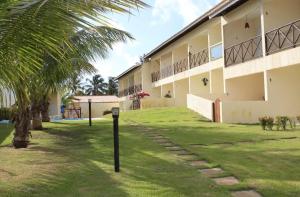 a building with a palm tree in front of it at Refúgio a 20km de Salvador na praia de Jacuípe in Camaçari