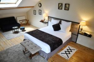 ein Schlafzimmer mit einem großen Bett und ein Wohnzimmer in der Unterkunft Les bergeronnettes - Chambres d'Hôtes Bergerac in Bergerac