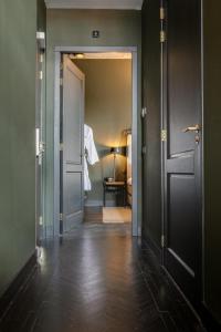 um corredor com uma porta aberta para um quarto em The Duke Boutique Hotel em Den Bosch