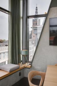 een kamer met een raam met een tafel en een lamp bij The Duke Boutique Hotel in Den Bosch