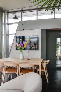 a dining room with a wooden table and flowers at The Duke Boutique Hotel in Den Bosch