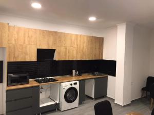 una cucina con fornelli e lavatrice di Hotel Niko a Kobuleti