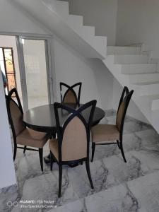 een eettafel en vier stoelen en een tafel en stoelen bij SWEET HOME YENNE in Rufisque