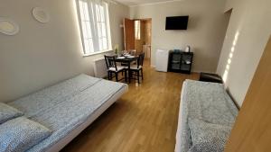 a room with two beds and a table with a dining room at Kwatery Mielenko Patraj in Mielenko