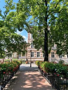 una pasarela frente a un edificio con árboles y flores en Atelier Hostel, en Leszno