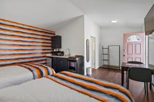 une chambre d'hôtel avec un lit et une cuisine dans l'établissement Wagon Wheel Motel, à Saco