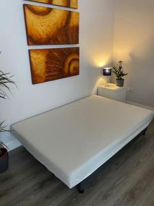 a white bed in a room with a painting on the wall at City Centre Studio Apartment in Dublin