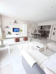 a white living room with a couch and a table at Appartement Sète proche centre ville in Sète