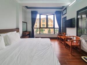ein Schlafzimmer mit einem großen weißen Bett und einem Fenster in der Unterkunft Hùng Trang Hotel Tam Đảo 1 in Tam Ðảo