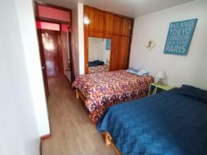 Habitación de hotel con 2 camas y espejo en FABRIZIO GUEST HOUSE, en Cusco