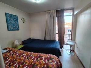 een slaapkamer met een bed en een raam met een balkon bij FABRIZIO GUEST HOUSE in Cuzco