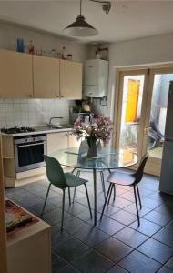 uma cozinha com uma mesa de vidro com cadeiras e um vaso de flores em 20 Gray Street em Dublin