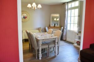 uma sala de jantar com uma mesa com cadeiras e um espelho em Les bergeronnettes - Chambres d'Hôtes Bergerac em Bergerac
