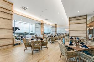 a restaurant with tables and chairs and windows at Daytona Grande Oceanfront Resort in Daytona Beach