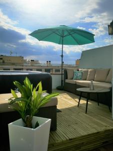 um pátio com um sofá e um guarda-chuva no telhado em "Rooftop One" jacuzzi - plein sud - 2 chambres sur les canaux em Empuriabrava