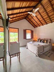um quarto com uma cama e uma ventoinha de tecto em Chalés Jatobá em Prados