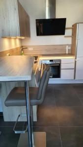 a kitchen with a table and a chair at a counter at Modern Apartment near Munich Airport in Oberding