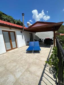 a patio with two blue chairs and a house at Love Holiday Suite 2 in Tris Elies