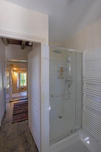 La salle de bains est pourvue d'une douche avec une porte en verre. dans l'établissement Le prieuré Saint Barthélémy, à Azay-le-Brûlé