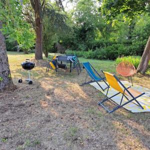 een groep stoelen en een grill in een tuin bij L'Atelier Gîte-Loft 6/8 pers in Pontlevoy