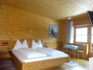 um quarto com uma cama num quarto de madeira em Landhaus Löberbauer em Tux
