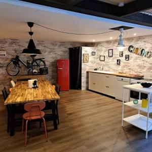 een kamer met een tafel en een keuken met een fiets aan de muur bij L'Atelier Gîte-Loft 6/8 pers in Pontlevoy