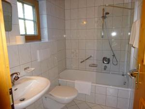 a bathroom with a tub and a toilet and a sink at Landhaus Löberbauer in Tux