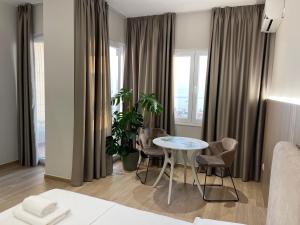 Deluxe Residence في دوريس: غرفة مع طاولة وكراسي ونافذة