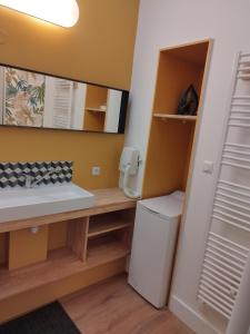 a bathroom with a sink and a washing machine at Le T.Green in La Gorgue