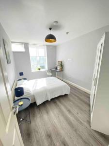 a white bedroom with a bed and a desk at Lovely 1 Bedroom apartment in Dublin 1 in Dublin