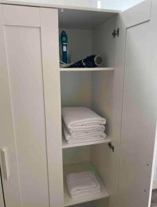a white cabinet with folded towels in a bathroom at Lovely 1 Bedroom apartment in Dublin 1 in Dublin
