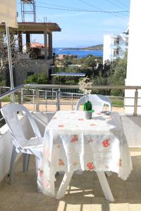 MyKsamil Apartments في كساميل: طاولة بيضاء وكراسي على شرفة مع المحيط