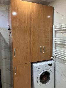 a washing machine in a kitchen with wooden cabinets at Önder suit in Rize
