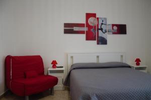 格拉尼亞諾的住宿－Home OLY，一间卧室配有一张床和一张红色椅子