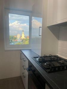 a kitchen with a stove and a large window at Karlsburg Suite in Alba Iulia +11 photos