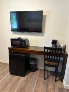 escritorio con microondas y TV en la pared en Crater Lake Gateway - Hwy 140, en Klamath Falls
