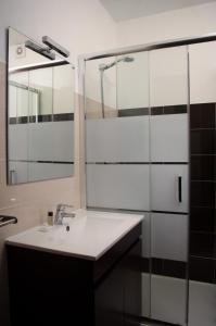 a bathroom with a sink and a mirror at Apartamentos Monte da Rosa in Vila Nova de Milfontes