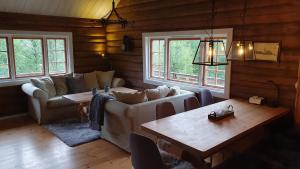 sala de estar con sofá y mesa en Cozy log cabin at beautiful Nystølsfjellet en Gol