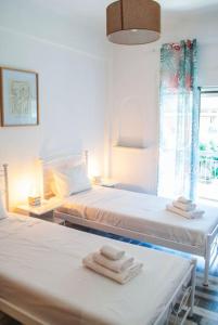 twee bedden in een kamer met handdoeken erop bij Your Athens Getaway: Stylish Apt in Athens in Athene