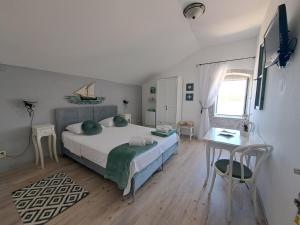 1 dormitorio con cama, mesa y escritorio en Heritage Rooms Kut en Vis